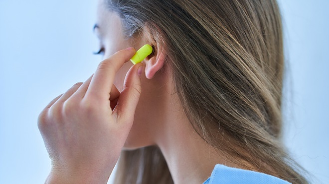 Une femme utilise des bouchons d'oreilles