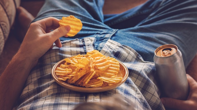 un homme mange des chips dans une assiette