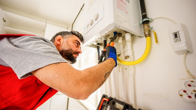 homme qui repare un chauffe-eau
