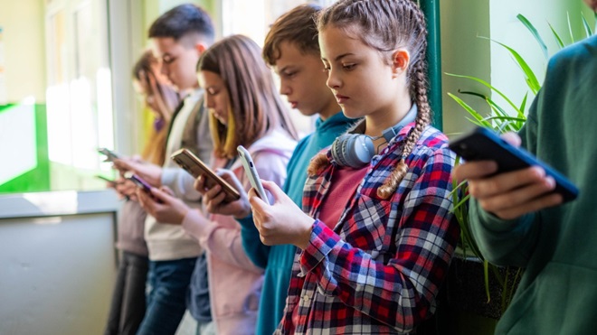 Des ados en train d'utiliser leur smartphone
