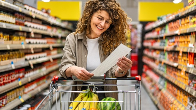 homme qui pousse un caddie dans une allée de supermarché avec une fille assise dessus où faire ses courses à l'étranger