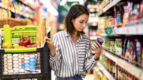 femme qui regarde des produits dans un rayon de supermarché
