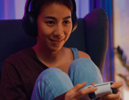 une femme tenant une manette de jeu pour playstation 5