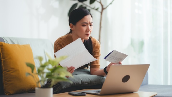 femme qui regarde une facture telecom avec son ordinateur