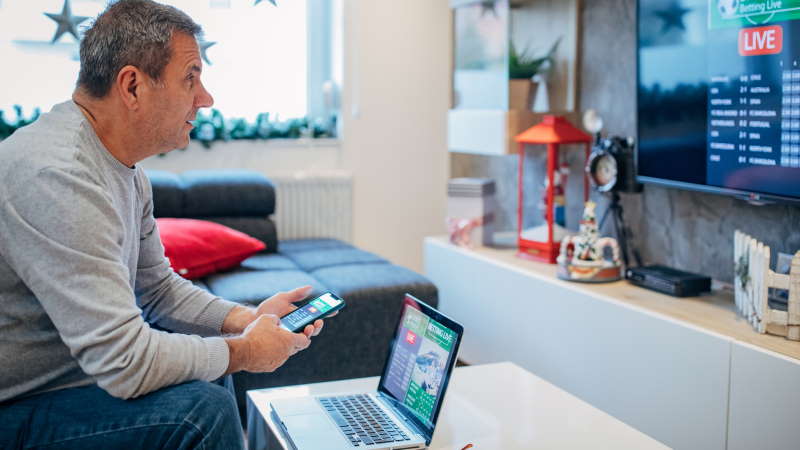 Une femme semble avoir du mal à choisir sa nouvelle TV dans un magasin.