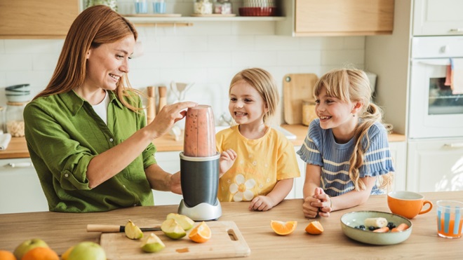 femme qui fait un smoothie avec un blender avec ses enfants 