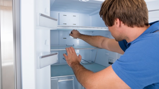 Un homme installe son nouveau frigo