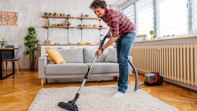 femme qui passe l'aspirateur sur un tapis