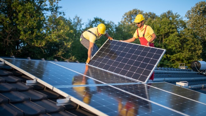 hommes installant panneaux solaires sur toit