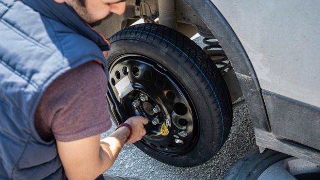 homme changeant un pneu