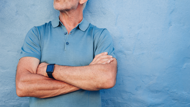 Un homme d'un certain âge avec une montre connectée au poignet.